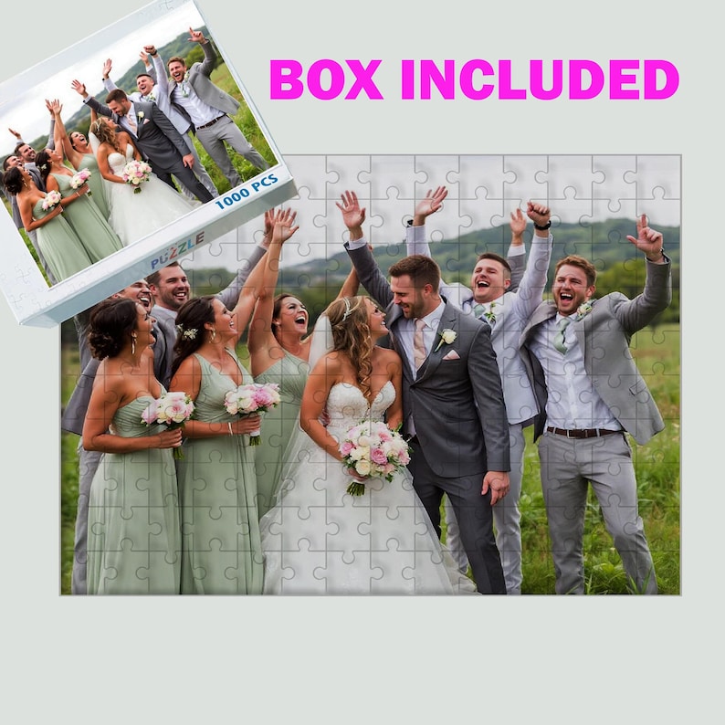 Puede incluir: Un rompecabezas de 1000 piezas con una foto de boda. La imagen muestra a una novia y un novio con su grupo de boda, todos sonriendo y celebrando. La caja del rompecabezas es visible, con el texto "BOX INCLUDED".