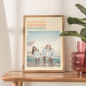 Puede incluir: Una impresi&oacute;n enmarcada con una est&eacute;tica vintage que presenta una foto de tres personas de pie en el oc&eacute;ano. El texto "Barbados" se repite tres veces en una fuente colorida en la parte superior de la impresi&oacute;n. El texto "Best Mom in the World!" est&aacute; en la parte inferior de la impresi&oacute;n.