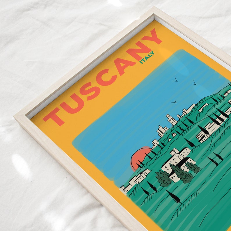 K&ouml;nnte beinhalten: Eine gelbe, blaue und gr&uuml;ne Illustration einer toskanischen Landschaft mit einer roten Sonne, die hinter einem Bergdorf untergeht. Der Text "Tuscany ITALY" steht in roten Buchstaben auf gelbem Hintergrund.
