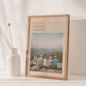 Puede incluir: Una impresi&oacute;n enmarcada con una foto de una familia sentada en la cima de una monta&ntilde;a. El texto "Canad&aacute;" se repite cuatro veces en una fuente colorida en la parte superior de la impresi&oacute;n. El texto "FORBIDDEN FAMILY ADVENTURES" est&aacute; en la parte inferior de la impresi&oacute;n.