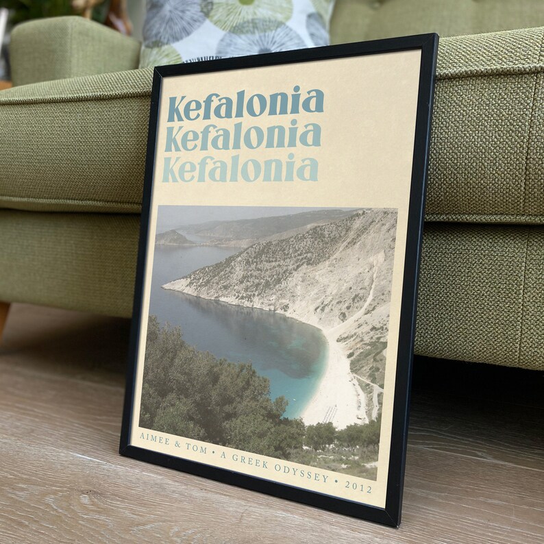 Puede incluir: Un p&oacute;ster enmarcado con una est&eacute;tica vintage que presenta una fotograf&iacute;a de una bah&iacute;a en Cefalonia, Grecia. El p&oacute;ster tiene el texto "Kefalonia" repetido tres veces en un color azul verdoso. El texto "Aimee & Tom - A Greek Odyssey - 2012" est&aacute; en la parte inferior del p&oacute;ster.