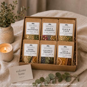 May include: A cardboard gift box containing six kraft paper pouches of stovetop simmer kits labeled New Beginnings, Love & Harmony, Peace & Calm, Home Blessing, Cleanse & Protect, and Joy & Abundance, with a welcome home card.