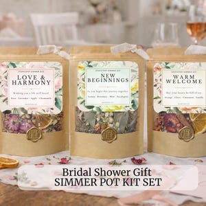 May include: Three kraft paper pouches filled with dried botanicals, each labeled with floral designs and text. The pouches are labeled "Love & Harmony", "New Beginnings", and "Warm Welcome". The text "Bridal Shower Gift SIMMER POT KIT SET" is at the bottom.