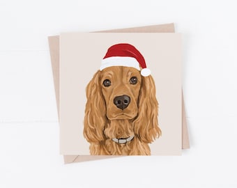 May include: A Christmas card featuring a golden cocker spaniel wearing a red Santa hat. The dog is looking directly at the viewer with a sweet expression.