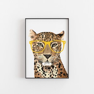 May include: A close-up of a leopard wearing yellow-framed glasses. The leopard's fur is brown and black with spots. The background is white.