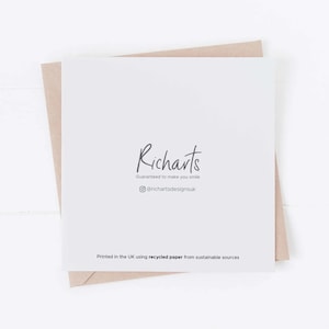 May include: A white card with the text "Richarts" in black script font. Below the text is the phrase "Guaranteed to make you smile" in smaller black font. Below that is a social media icon and the text "@richartsdesignsuk". At the bottom of the card is the text "Printed in the UK using recycled paper from sustainable sources".