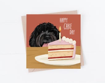 Könnte beinhalten: Eine Geburtstagskarte mit einem schwarzen Hund, der über ein Stück rosa Kuchen mit einer brennenden Kerze schaut. Die Karte lautet "Happy Cake Day".