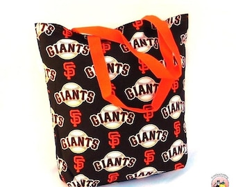 May include: A black tote bag with orange straps and a repeating pattern of baseballs and the words "Giants" and "SF".