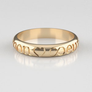 May include: A gold band ring with the words "Love" and "Forever" engraved on it, along with a heart and infinity symbol.