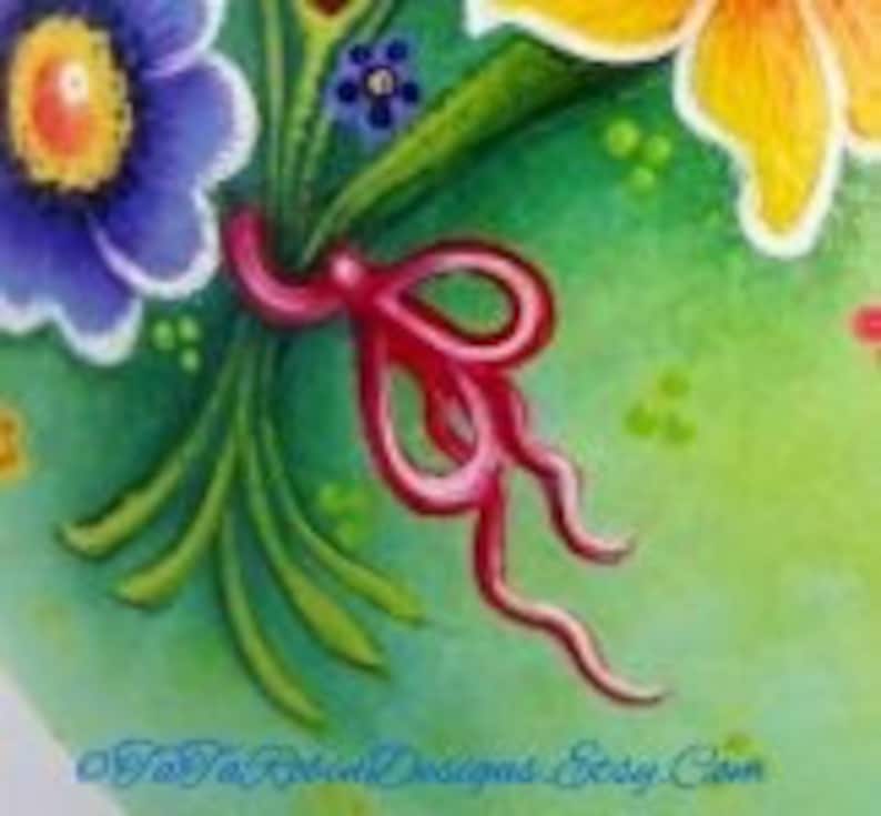 May include: A bouquet of flowers tied together with a pink ribbon. The flowers are yellow, blue, and white. The background is green.