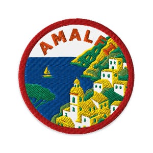 May include: Embroidered patch featuring a coastal Italian town scene. The design includes the word "AMAL" in orange letters, a blue sea with a sailboat, and yellow buildings on a hillside, all framed by a red border.