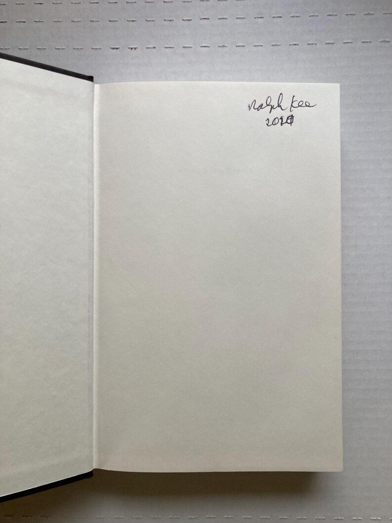 May include: A blank white page of a book with black binding. The page has a handwritten signature that says "Ralph Lee 2018".