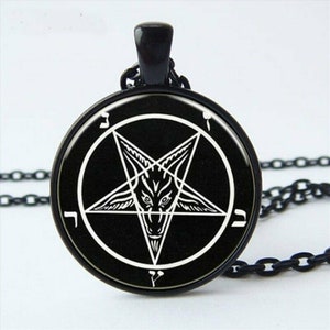 May include: A black pendant necklace with a silver pentagram charm featuring a goat's head inside. The pentagram is surrounded by a circle with Hebrew lettering.
