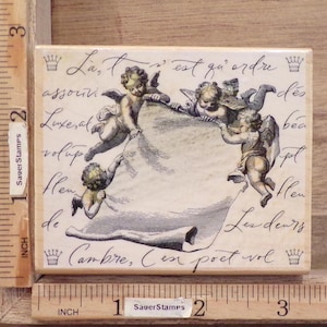 May include: A vintage-style rubber stamp with a white background and a design of cherubs holding a banner with the text "La, l'on est qu'ordre des bea pt flen de Cambre, Cen poet vol".