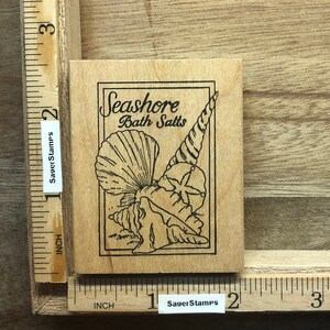 May include: Wooden stamp with a black and white illustration of seashells and the text "Seashore Bath Salts".