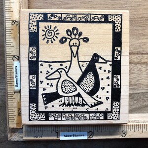 May include: A black and white rubber stamp with a design of three birds. The birds are stylized and have a geometric pattern. The stamp is surrounded by a black and white border with a repeating pattern of stars and swirls. The stamp is labeled "SagerStamps".
