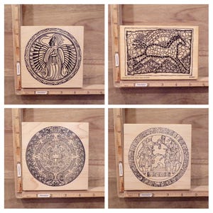 May include: Four wooden blocks with black and white designs. The designs are of a winged figure, a mosaic pattern, and two different circular designs. The blocks are approximately 2 inches by 2 inches.