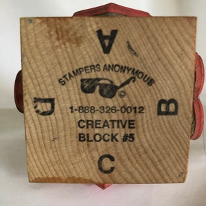 May include: A wooden block with the text "Stampers Anonymous" and a pair of sunglasses logo. The block also has the text "1-888-326-0012", "Creative Block #5", and the letters "A", "B", "C", and "D".