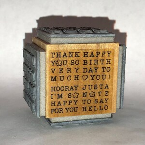 May include: Wooden stamp with a message that reads "THANK HAPPY YOU SO BIRTH VERY DAY TO MUCH YOU! HOORAY JUSTA I'M SANTE HAPPY TO SAY FOR YOU HELLO"