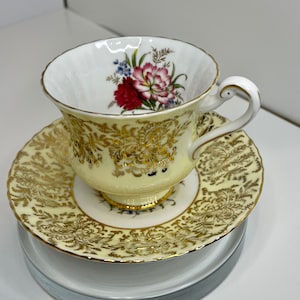 Vintage Paragon yellow with gold Carnations teacup with matching saucer. Made in England.