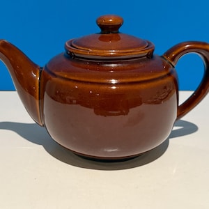 May include: A set of three ceramic mugs with a speckled, matte finish in cream, light brown, and dark brown. Each mug has a simple, minimalist design, ideal for tea or coffee.