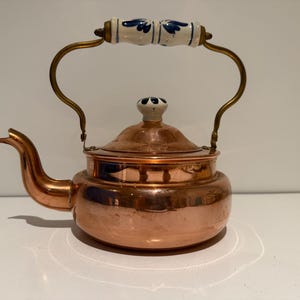Bouilloire vintage en cuivre et laiton avec poignée et bouton de couvercle en porcelaine de Delft.