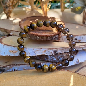 Puede incluir: Una taza de cerámica blanca con un asa negra y el texto "But First, Coffee" en un estilo manuscrito. La taza está sobre una superficie blanca. La taza mide aproximadamente 10 cm de alto.