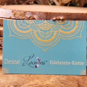 Może przedstawiać: Turkusowa wizyt&oacute;wka z złotym wzorem mandali. Tekst na wizyt&oacute;wce brzmi "Deine Laconi Edelstein-Kette".