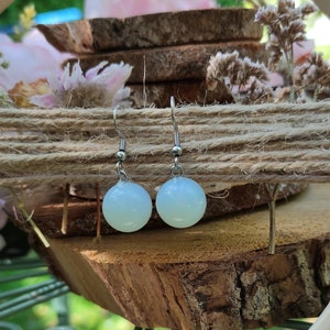 May include: A pair of silver earrings with light blue round glass beads.