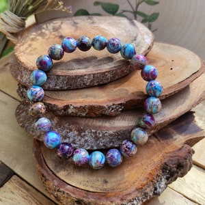 May include: A blue, purple and brown patterned stone bracelet with round beads.