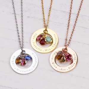May include: Three gold, silver, and rose gold necklaces with personalized engraved circles and colorful gemstone charms. The circles are engraved with names, including John, Isabella, Mia, Charlotte, Abigail, Michelle, Stephanie, Olivia, Liam, Ava, Ethan, and Theo.