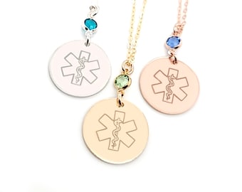 May include: Three silver, gold, and rose gold necklaces with a round pendant featuring a medical symbol and a small crystal charm. The charms are blue, green, and light blue.