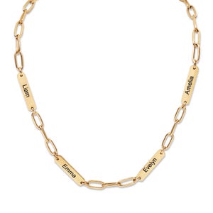 May include: A gold-colored chain necklace with four rectangular nameplates. Each plate is engraved with a name: Liam, Emma, Evelyn, and Amelia. The necklace has a delicate, elegant design.