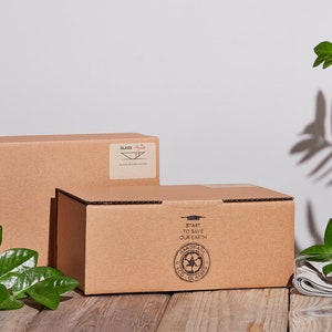 May include: Two brown cardboard boxes with printed text. The top box has the words "Start to Save Our Earth" and a green recycling symbol. The bottom box has the word "Glass" and a symbol of a glass dish.