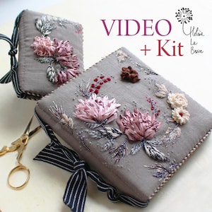 Peut inclure: Deux livres recouverts de tissu gris avec broderie florale au ruban. Les livres présentent des fleurs roses et crème, des baies rouges et des accents de perles argentées. Le texte "VIDEO + Kit" est visible.
