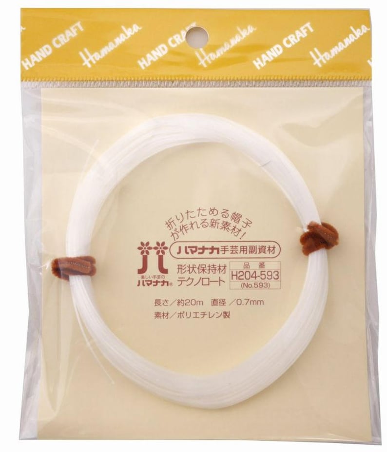 Puede incluir: Un paquete de Hamanaka Techno-Rope blanco, un material artesanal para hacer sombreros. El paquete incluye una bobina de cuerda blanca, asegurada con dos cierres marrones. El texto en el paquete incluye "HAND CRAFT" y texto japon&eacute;s.