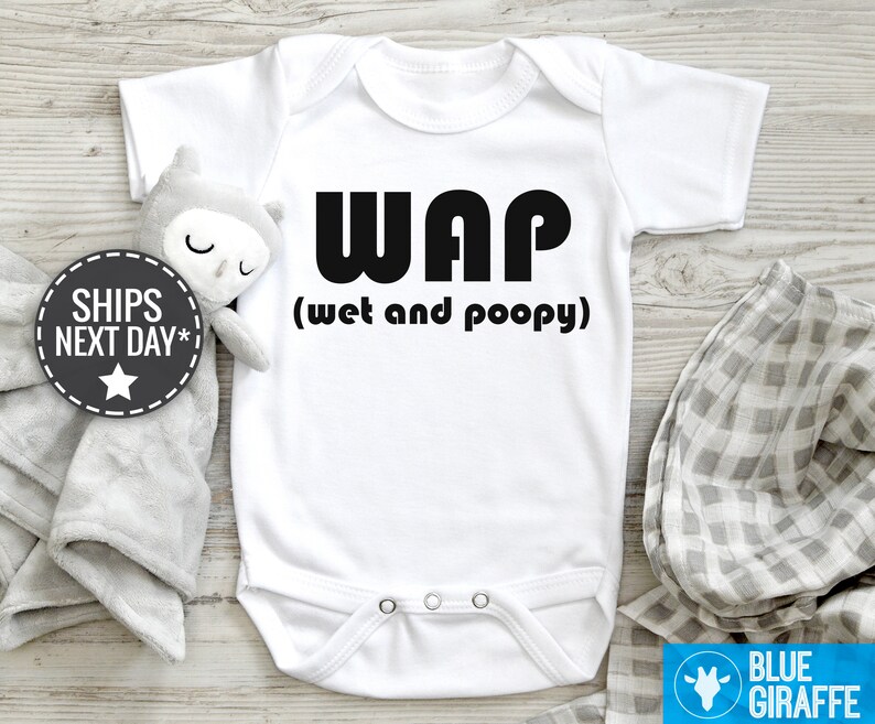以下が含まれることがあります： 白いベビーロンパースに、黒い文字で「WAP（ウェットアンドプーピー）」と書かれています。