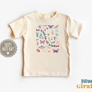 May include: Cream-colored t-shirt featuring a colorful insect and butterfly graphic with the text "be kind to all kinds." The design includes various insects and butterflies in shades of blue, purple, green, and red. The shirt is a children's apparel item.