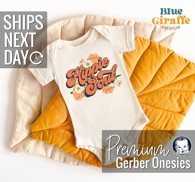 May include: White baby onesie with the text "Hippie Soul" in orange and pink lettering with floral accents. The onesie is on a yellow and beige textured surface.