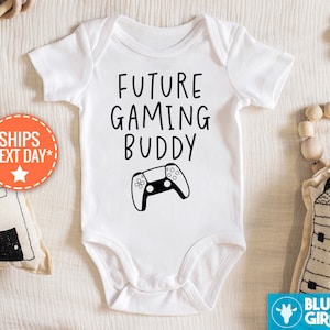 Può includere: Body bianco per neonato con testo nero che recita "Future Gaming Buddy" e un'illustrazione in bianco e nero di un controller per videogiochi.