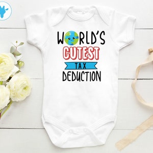 May include: White baby onesie with the text "World's Cutest Tax Deduction" in black. A cartoon earth with a smiling face is above the text.