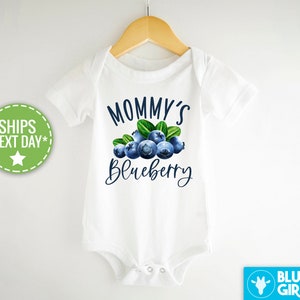 May include: White baby bodysuit with a blue and green blueberry graphic and the text "Mommy's Blueberry".