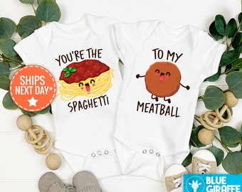 May include: Two white baby onesies with a spaghetti and meatball theme. The onesie on the left says "You're the Spaghetti" with a cartoon spaghetti noodle with a face. The onesie on the right says "To My Meatball" with a cartoon meatball with a face.