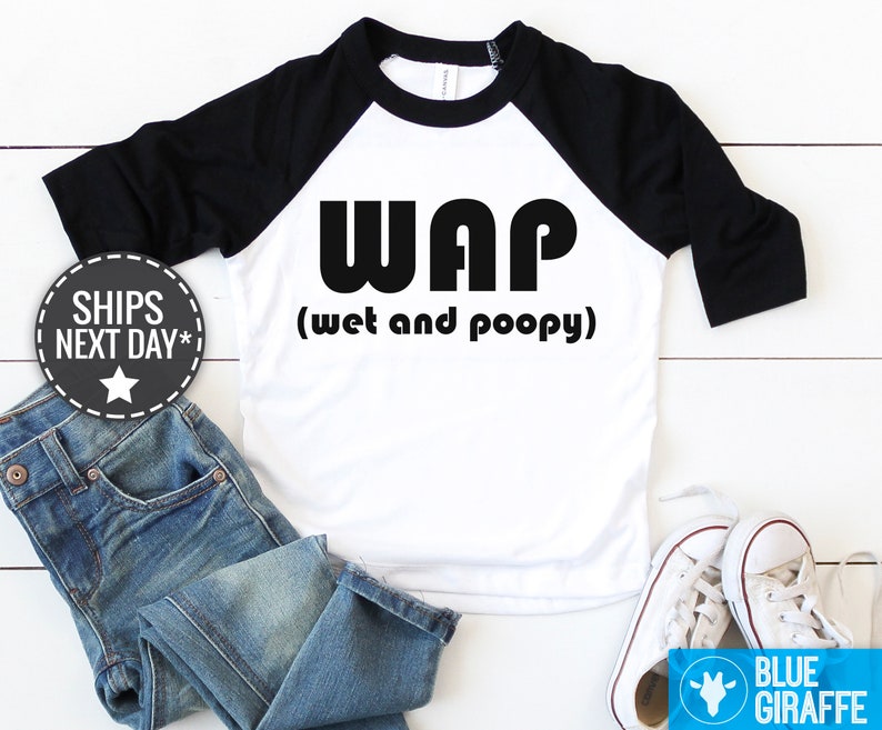 以下が含まれることがあります： 白と黒のベースボールTシャツに、黒で「WAP（ウェットアンドプーピー）」の文字が書かれています。シャツは黒のラグランスリーブです。