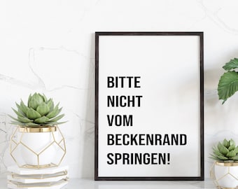 May include: A black framed poster with white background and the text "Bitte nicht vom Beckenrand springen!" in black. The poster is on a white marble shelf with two potted plants, one in a white pot and the other in a gold geometric pot.