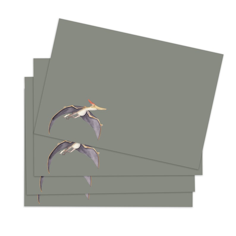May include: A stack of four green note cards with a flying pterosaur illustration on each card.