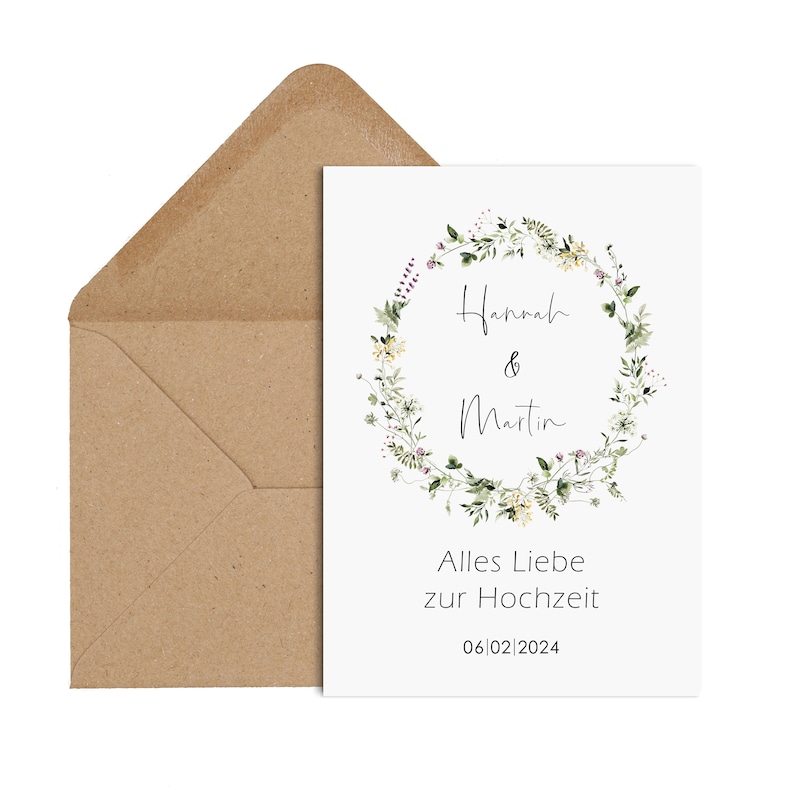 May include: A white card with a floral wreath design. The wreath is made of green leaves and yellow flowers. The text "Hannah & Martin" is in the center of the wreath. The text "Alles Liebe zur Hochzeit" and the date "06/02/2024" are below the wreath.