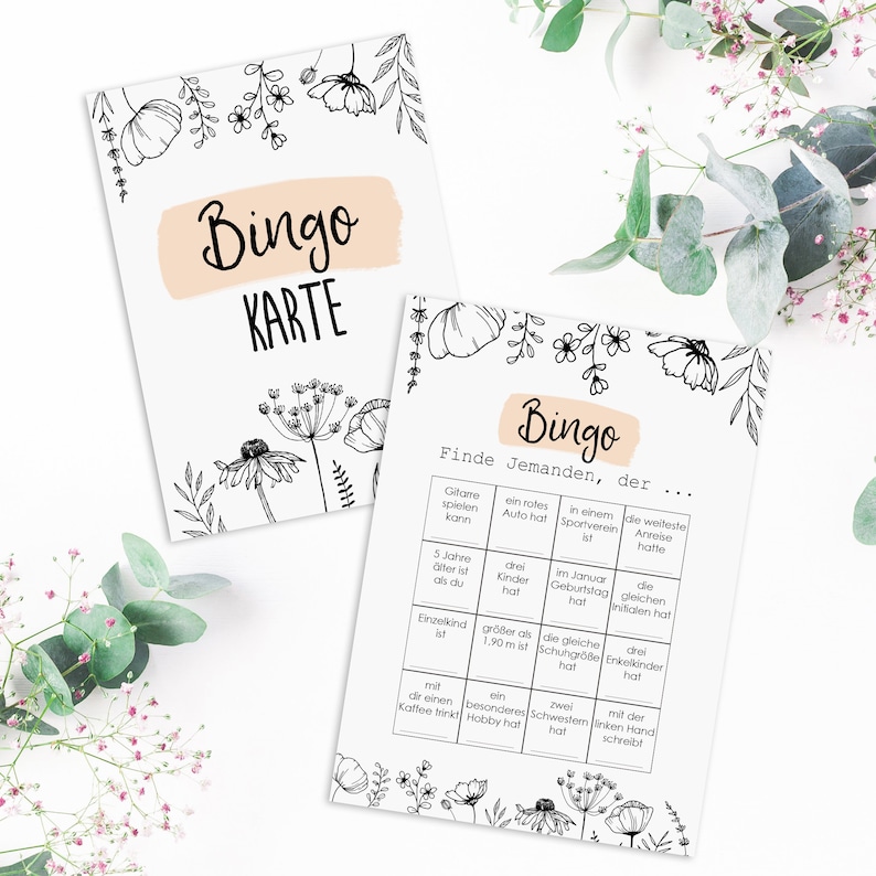 May include: A black and white bingo card with floral accents. The card has a title that says "Bingo" and instructions that say "Find someone who..." with a list of prompts.