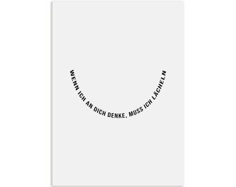 May include: A white background with black text that reads "WENN ICH AN DICH DENKE, MUSS ICH LÄCHELN" in a curved arc, forming a smiley face.