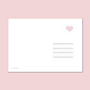 Op de afbeelding: Een blanco witte kaart met een roze hart in de rechterbovenhoek. De kaart heeft drie gestippelde lijnen om op te schrijven en de tekst "NASTAMI" onderaan.